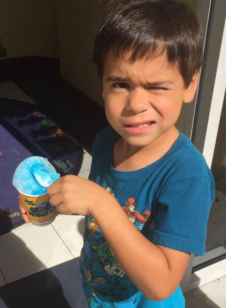 A boy eats a snow cone at Educare